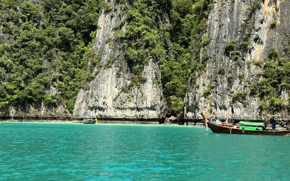 A speedboat running between the limestone islands of the Andaman Sea